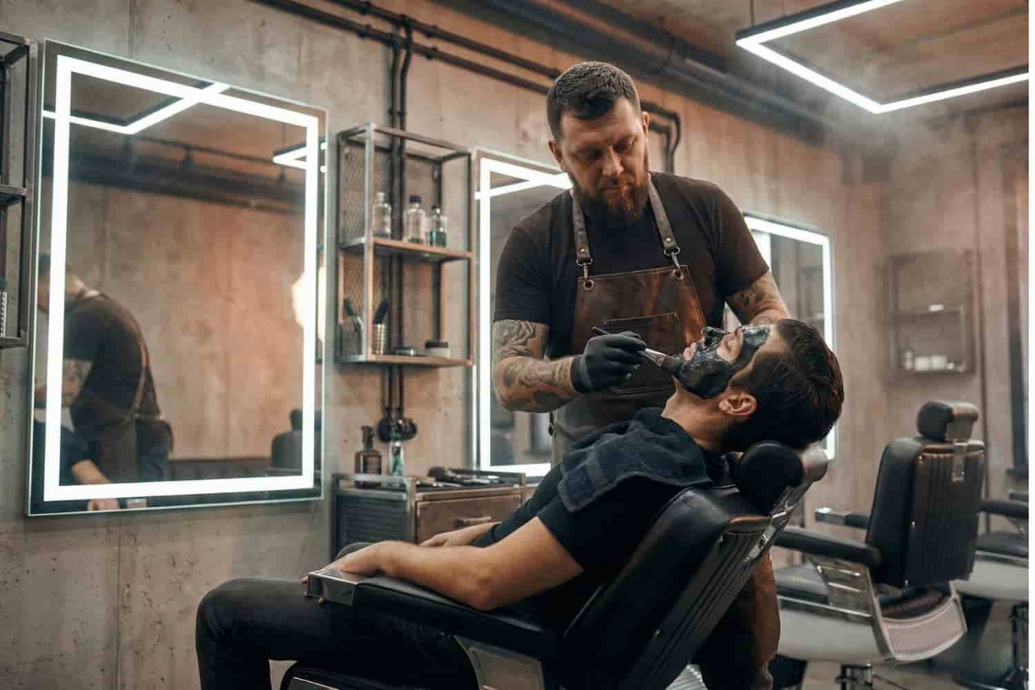 Barbero aplicando mascarilla negra de carbón activado para limpieza facial profunda y eliminación de puntos negros en Ecatepec.